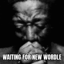a man is praying with his hands folded in a black and white photo .