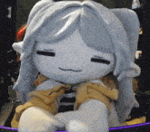 a stuffed animal with long white hair is sitting on a desk