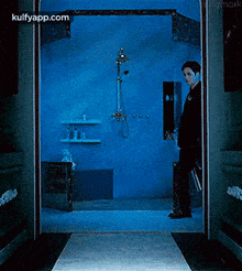 a man is walking into a bathroom with a briefcase .