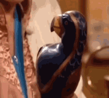 a close up of a person holding a statue of a parrot in their hand