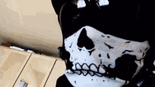 a person wearing a black and white skull mask with teeth