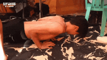a shirtless man is doing push ups in front of a sign that says 21p ness