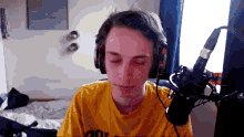 a young man wearing headphones and a yellow shirt that says ' aol ' on it