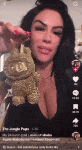 a woman in a black top is holding a gold item