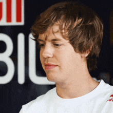 a man wearing a white shirt with a red bull logo on the sleeve