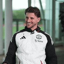 a man wearing a black and white adidas jacket with the number 7 on it