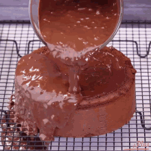 a chocolate cake is being covered in chocolate icing