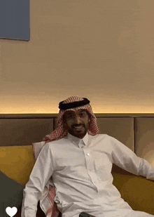 a man in a white shirt is sitting on a couch