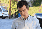 a man in a blue shirt is standing in front of a truck that says trd