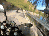 a motorcycle is driving down a road with a reflection of a car in the mirror