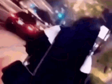 a blurry picture of a person holding a cell phone in their hand .