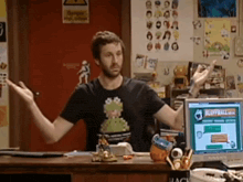 a man is standing in front of a computer screen that says bluffball.com on it
