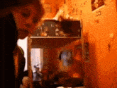 a blurred image of a person standing in front of an orange wall with a sticker on it that says ' a '