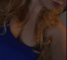 a close up of a woman 's neck and shoulder in a blue top .