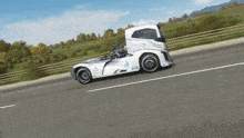 a white truck with the number 26 on the side is driving down the road
