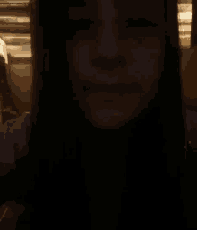 a woman 's face is shown in a dark room