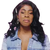 a woman wearing a denim jacket and a necklace with the letter c