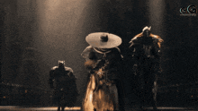 a man in a cowboy hat is kneeling down in a dark room with the letters gg in the corner