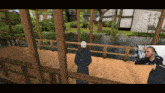 a man stands on a wooden deck overlooking a body of water in a video game