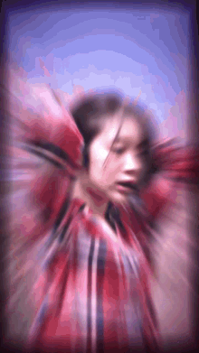 a blurry picture of a woman in a red and black plaid shirt