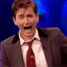 a man in a suit and tie making a funny face