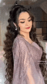 a woman with long hair is wearing a dress and earrings .