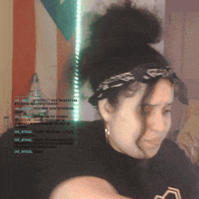 a woman wearing a headband and a black shirt has a bun