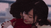 two women are hugging each other in a room .