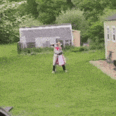 a man in a knight costume is standing in the grass giving the middle finger