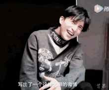 a young man wearing a sweater with the word pencil on it is smiling