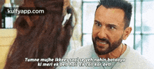 a man with a beard is talking to a woman on a phone .