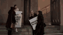 a group of women are holding signs that say welcome to church