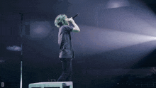 a person singing into a microphone with the letter d visible