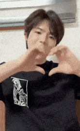 a man making a heart shape with his hands