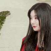 a woman with long black hair wearing a red shirt