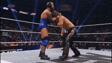 two men are wrestling in a ring with a crowd watching and a sign that says aew on it