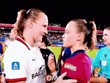 two female soccer players are hugging and one has bimbo written on her shirt