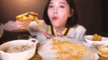 a woman is eating a slice of pizza at a table