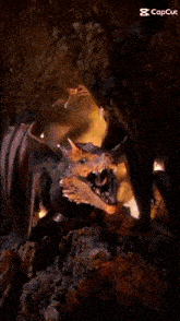 a dragon is coming out of a cave with a flame coming out of its mouth .