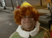 a man wearing a wig and hat is standing on a street