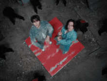 a man and a woman are standing on a red carpet