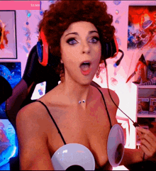 a woman wearing a wig and headphones is sitting in front of a screen that says $ 1,500 on it