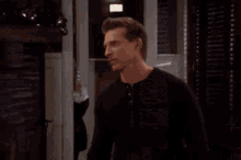 a man and a woman are standing next to each other in a living room .