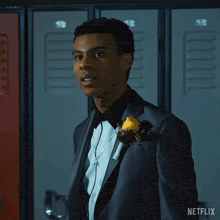 a man in a tuxedo says it 's over in front of lockers