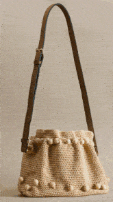 a crocheted purse filled with yellow and white flowers