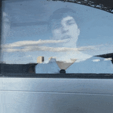 a reflection of a man in a window that says ' caballero ' on it