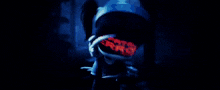 a person is standing in a dark room with a purple light coming out of their face .