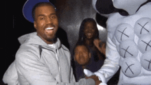 a man in a gray jacket is shaking hands with a person in a white outfit with x 's on it