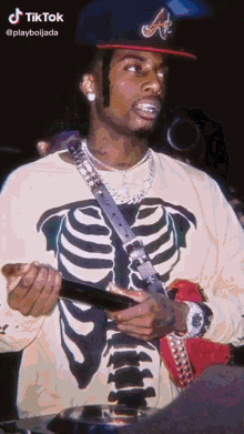 a man wearing a skeleton shirt and a hat with the letter a