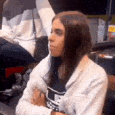 a woman is sitting at a table in front of a sign that says ' abercrombie & fitch ' on it .